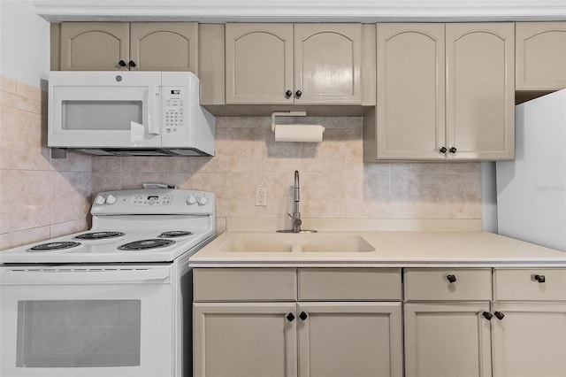 kitchen with cream cabinets, white appliances, backsplash, and sink