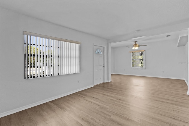 empty room with ceiling fan and light hardwood / wood-style floors