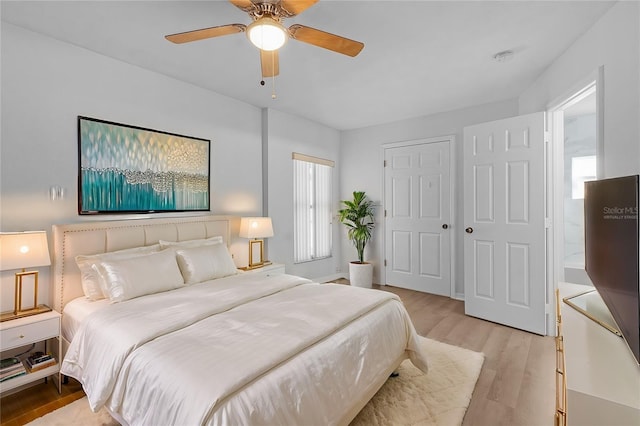 bedroom featuring ceiling fan, a closet, and light hardwood / wood-style flooring