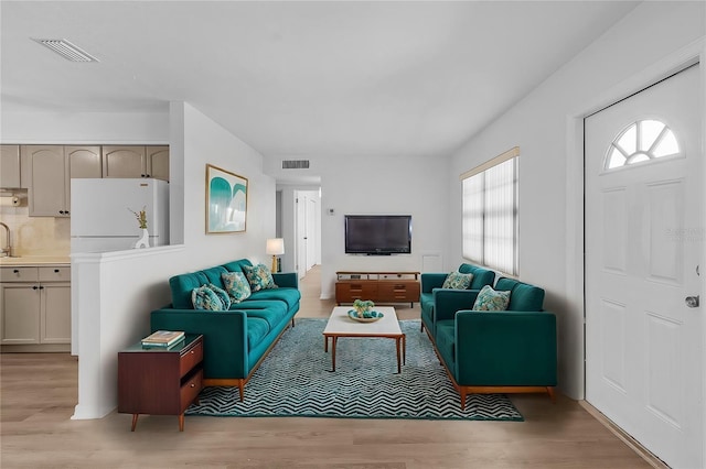 living room with sink and light hardwood / wood-style floors