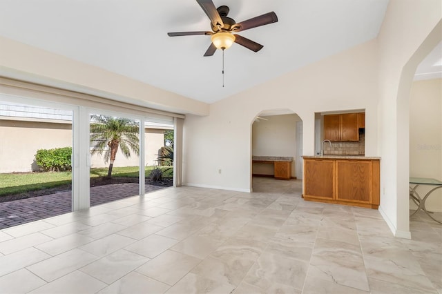 unfurnished living room with ceiling fan and lofted ceiling