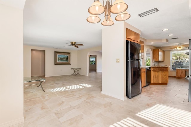 kitchen featuring black appliances, ceiling fan with notable chandelier, sink, hanging light fixtures, and kitchen peninsula