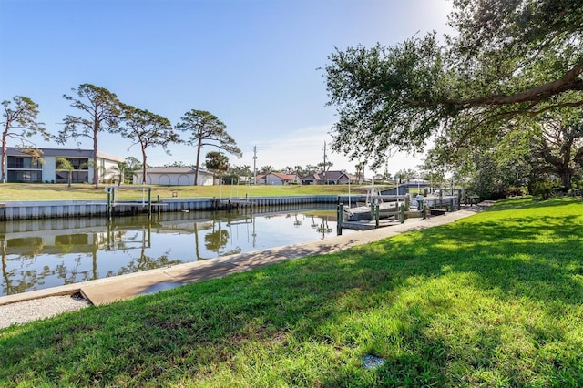 dock area with a water view and a lawn