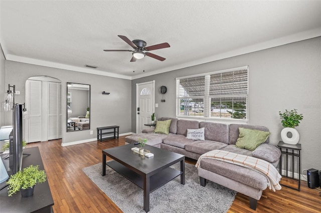 living room featuring dark wood-type flooring and ceiling fan