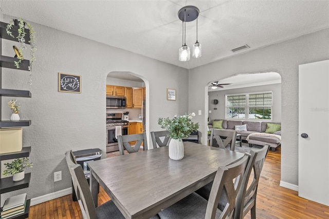 dining area with hardwood / wood-style flooring and ceiling fan