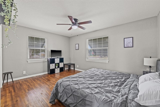 bedroom with ceiling fan, dark hardwood / wood-style flooring, and a textured ceiling