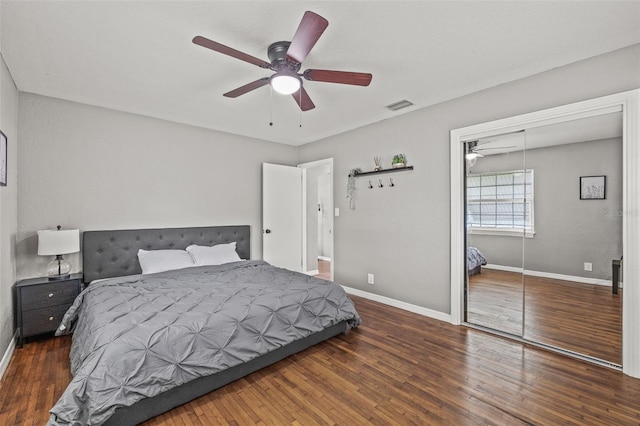 bedroom featuring dark wood-type flooring, a closet, and ceiling fan