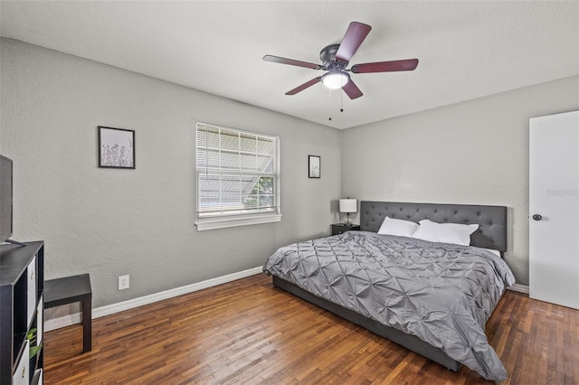 bedroom with dark hardwood / wood-style flooring and ceiling fan