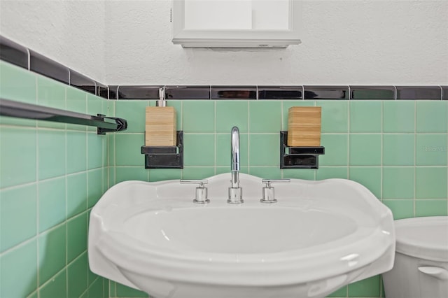 bathroom with tile walls and sink