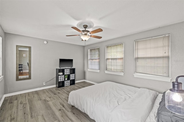 bedroom with ceiling fan and light hardwood / wood-style flooring