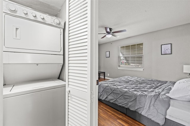 bedroom with stacked washer and clothes dryer, dark hardwood / wood-style flooring, and a textured ceiling