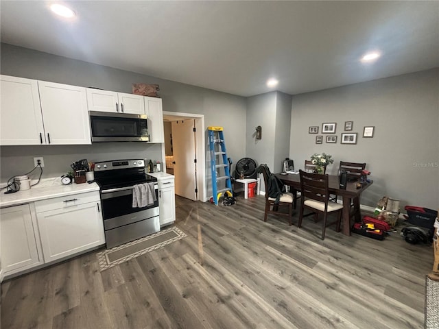 kitchen with white cabinetry, appliances with stainless steel finishes, and hardwood / wood-style floors