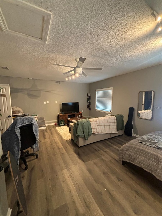 bedroom featuring hardwood / wood-style flooring, ceiling fan, and a textured ceiling