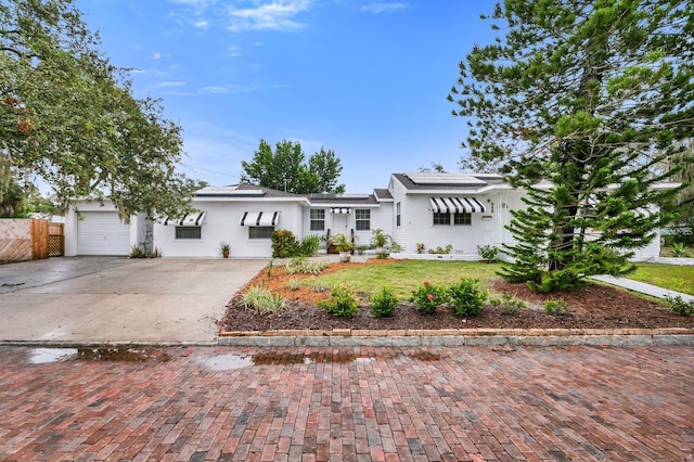 ranch-style house featuring a garage and a front lawn