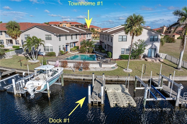 dock area featuring a water view, a fenced in pool, and a lawn