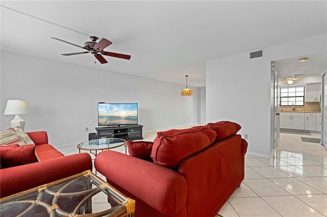 tiled living room featuring ceiling fan and sink