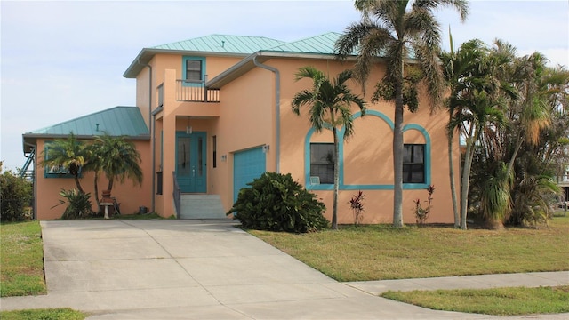 mediterranean / spanish-style home featuring a front yard and a garage