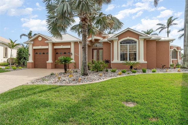 view of front of property featuring a front lawn, a garage, and french doors