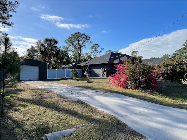 exterior space featuring a garage, an outbuilding, and a front yard