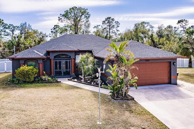 ranch-style house with a front lawn, a garage, and french doors