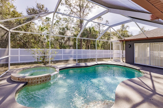 view of swimming pool featuring glass enclosure, a patio area, and an in ground hot tub