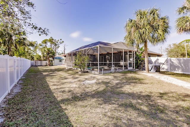 rear view of property with a lawn, glass enclosure, and a pool