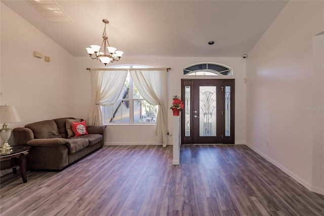 foyer with lofted ceiling, dark hardwood / wood-style floors, and a notable chandelier