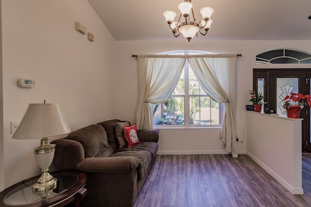 living room with hardwood / wood-style floors, lofted ceiling, and a notable chandelier