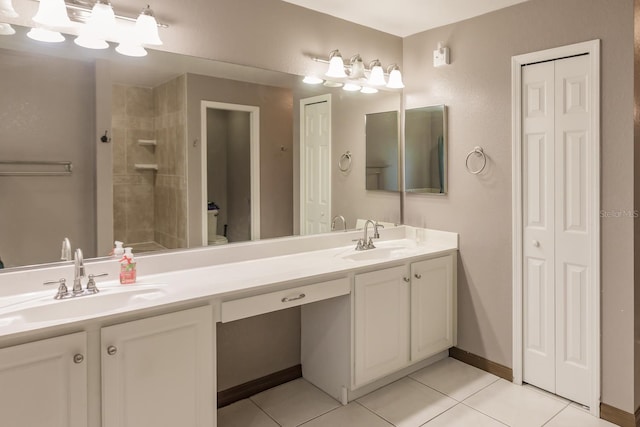 bathroom featuring a tile shower, tile patterned flooring, and vanity