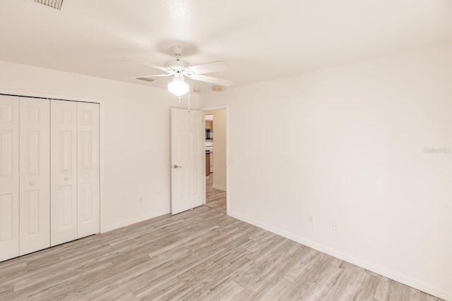 unfurnished bedroom with a closet, light hardwood / wood-style flooring, and ceiling fan