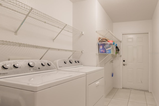 clothes washing area featuring light tile patterned floors and washing machine and clothes dryer