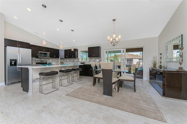 dining area with a chandelier and lofted ceiling