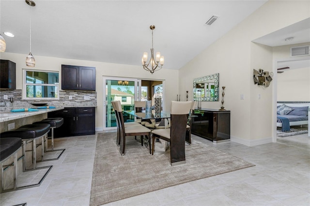 dining area featuring lofted ceiling and a notable chandelier