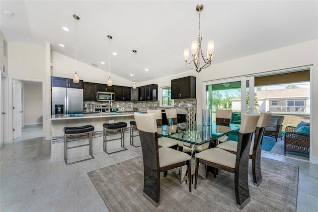 dining space with lofted ceiling, sink, and an inviting chandelier