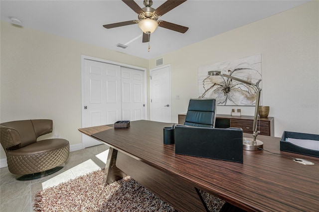 tiled home office featuring ceiling fan