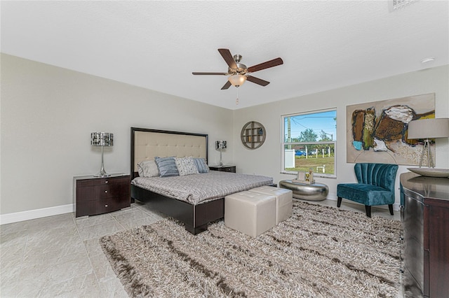 bedroom with ceiling fan and a textured ceiling