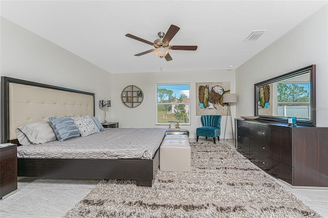 bedroom with ceiling fan and a textured ceiling