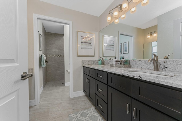 bathroom featuring a tile shower and vanity