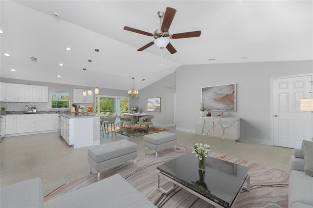 living room featuring vaulted ceiling, ceiling fan with notable chandelier, and light tile patterned flooring