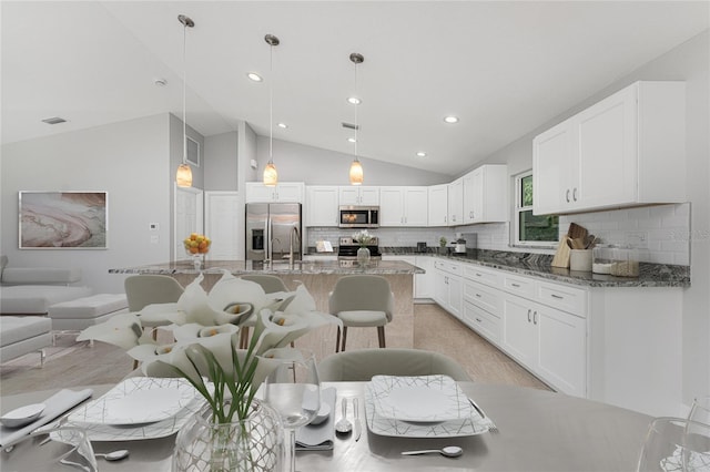 kitchen featuring decorative light fixtures, white cabinetry, appliances with stainless steel finishes, and decorative backsplash