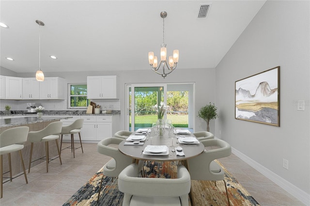 tiled dining room with lofted ceiling and an inviting chandelier