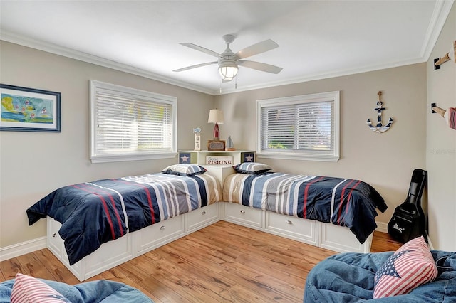 bedroom featuring light hardwood / wood-style flooring, ceiling fan, and crown molding