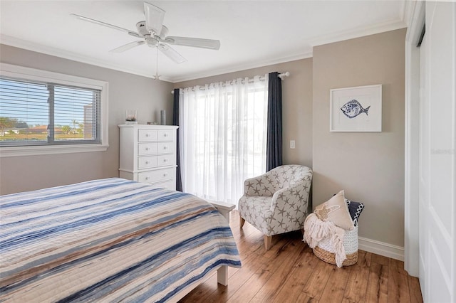 bedroom featuring hardwood / wood-style floors, a closet, ceiling fan, and ornamental molding