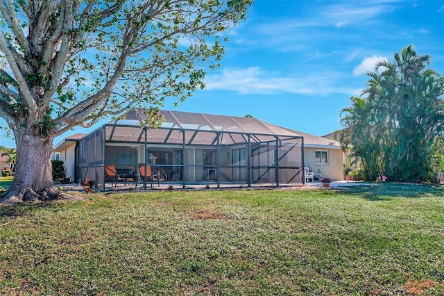 back of house with glass enclosure and a yard