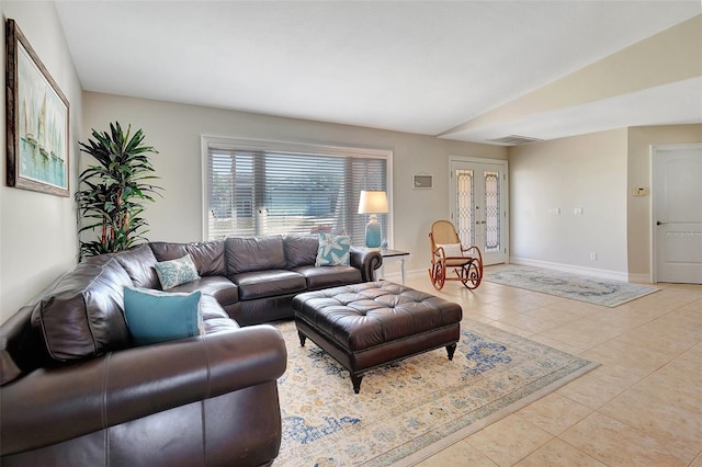 tiled living room featuring french doors and vaulted ceiling