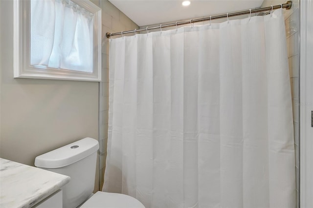 bathroom with vanity, curtained shower, and toilet