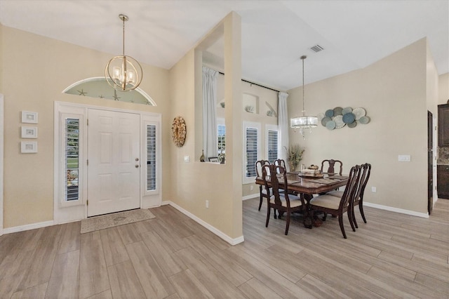 foyer featuring a towering ceiling, a chandelier, and light hardwood / wood-style flooring