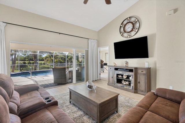 living room with ceiling fan, light hardwood / wood-style flooring, and high vaulted ceiling