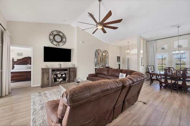 living room featuring ceiling fan with notable chandelier and lofted ceiling