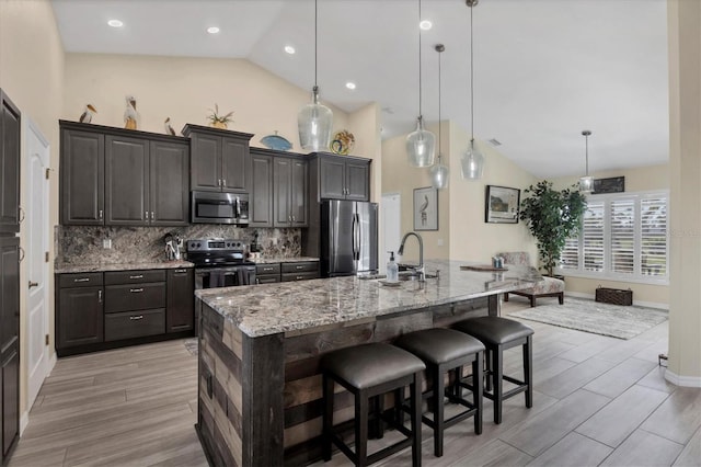 kitchen featuring hanging light fixtures, a large island, sink, a kitchen bar, and stainless steel appliances